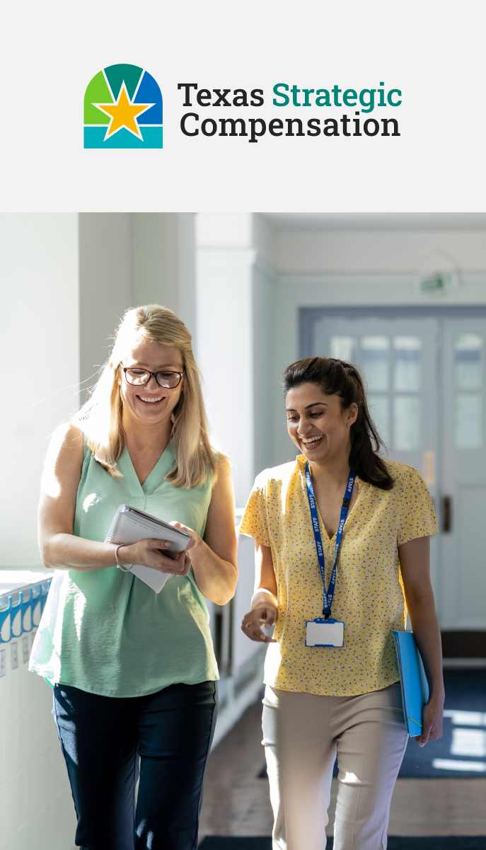 Two educators walking down hall reviewing paperwork